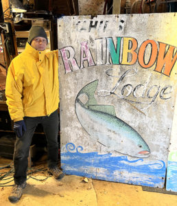 Picture of Geoff Baer with Rainbow Lodge sign